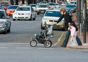 Woman with stroller and child on pedestrian crossing